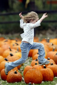 girl leaping pumpkins